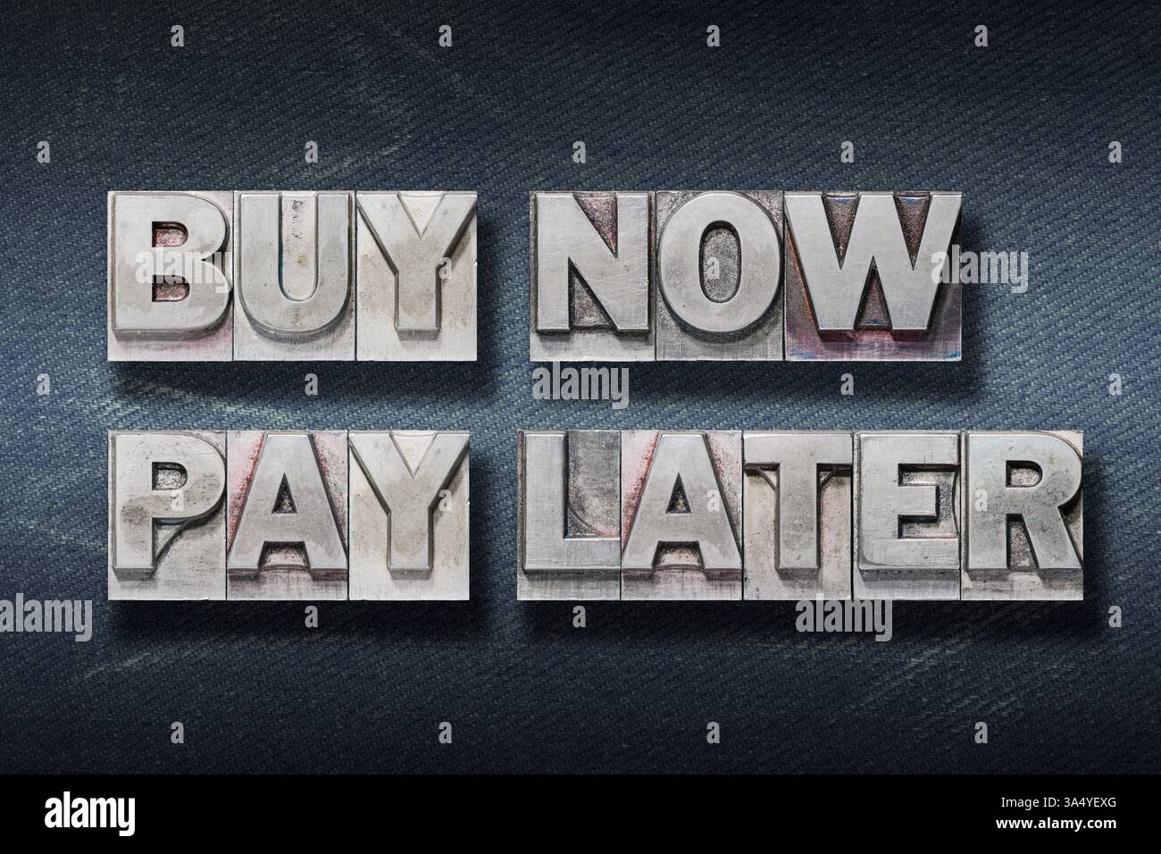 acheter maintenant, payer plus tard phrase faite à partir de typographie métallique sur fond de jeans foncé Banque D'Images