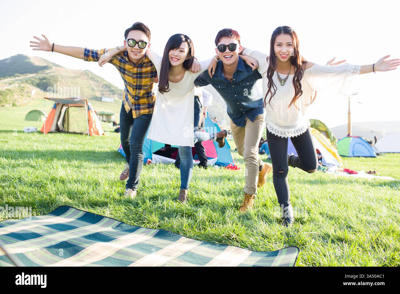 Heureux amis chinois apprécient un festival de musique en plein air. L'image transmet la jeunesse, l'amitié et l'énergie du divertissement en direct. Parfait pour la couverture du style de vie, des voyages et des festivals. Banque D'Images