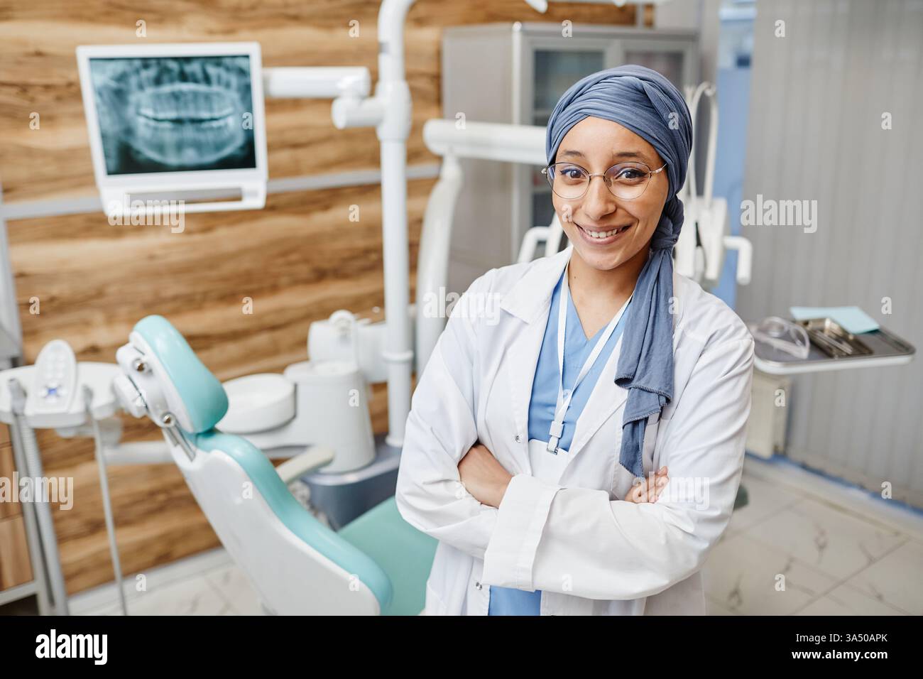 Portrait à la taille d'une femme musulmane dentiste dans une clinique dentaire moderne, regardant la caméra avec espace de copie. Une image de santé propre adaptée à la dentisterie, au professionnalisme médical et aux campagnes de diversité. Banque D'Images