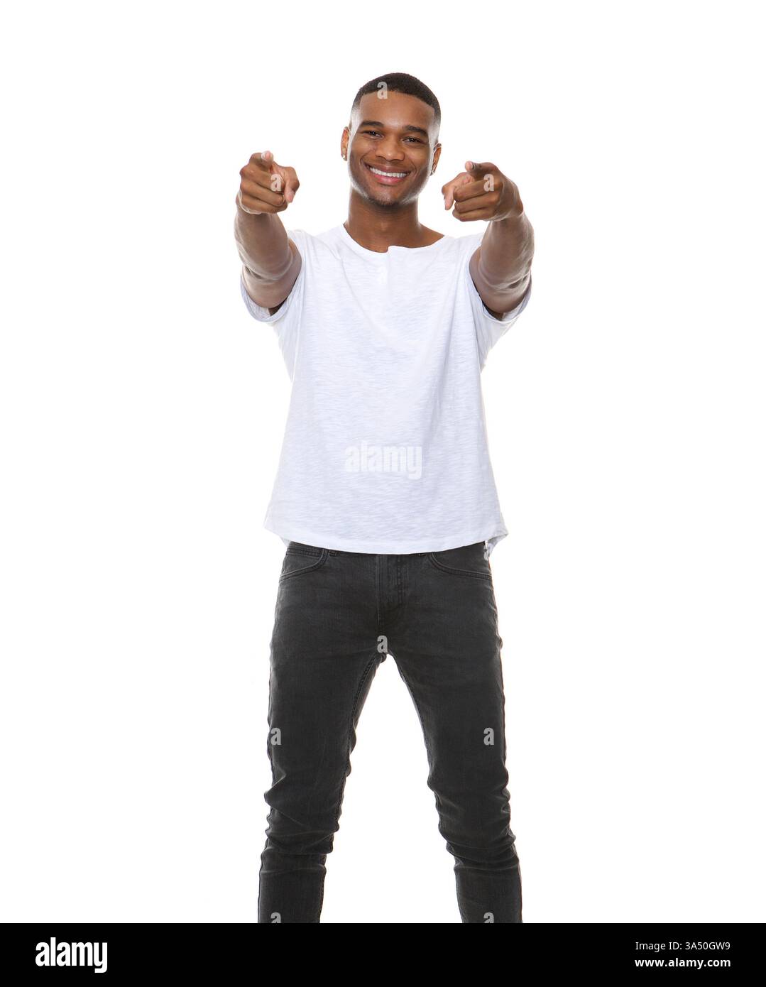 L'homme afro-américain souriant pointe en avant dans un studio propre sur un fond blanc. Ce portrait confiant exprime la motivation, le leadership et une ambiance positive et tournée vers l'avenir. Idéal pour les publicités, les communications d'entreprise et les campagnes de style de vie qui mettent l'accent sur l'ambition et le succès. Banque D'Images