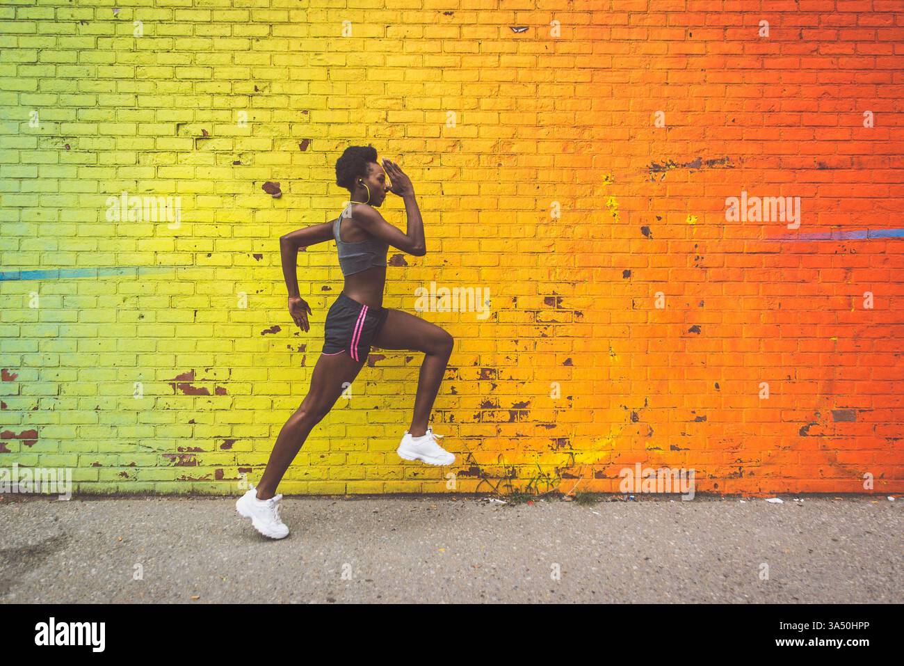 Athlète femme s'entraîne en plein air au lever du soleil à Brooklyn, New York, avec l'horizon de la ville en arrière-plan. L'image exprime la motivation, la forme physique et un style de vie actif. Banque D'Images