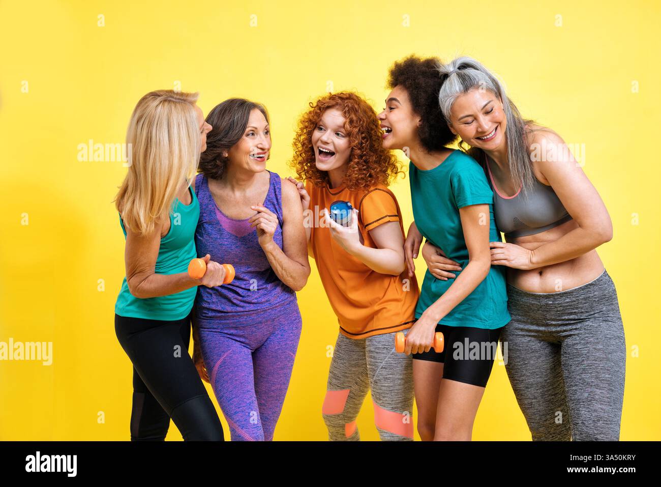 Groupe de femmes de différents âges et ethnies s'exerçant ensemble dans un gymnase. La scène favorise la positivité corporelle, la forme physique et l'inclusivité dans le sport. Une représentation vibrante de femmes diverses qui restent en bonne santé et actives. Banque D'Images