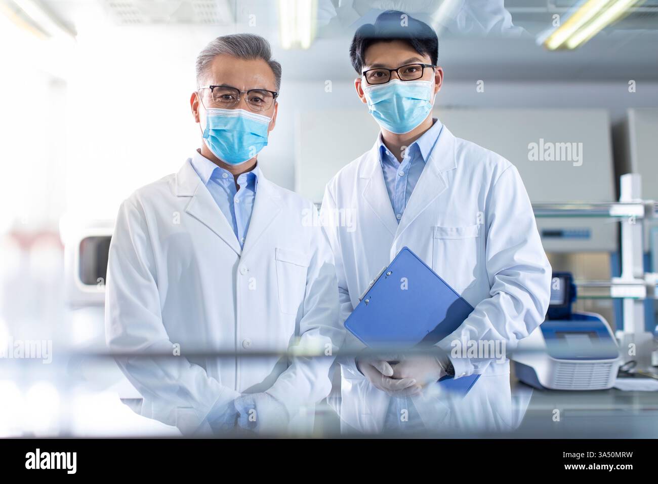 Portrait de chercheurs chinois masculins dans un laboratoire. L'image montre des scientifiques au travail avec des équipements de laboratoire dans un cadre intérieur, capturant la précision dans les tests génétiques et la recherche médicale à Pékin. Un portrait professionnel axé sur la science, adapté aux biotechnologies, aux soins de santé et aux thèmes de recherche. Banque D'Images