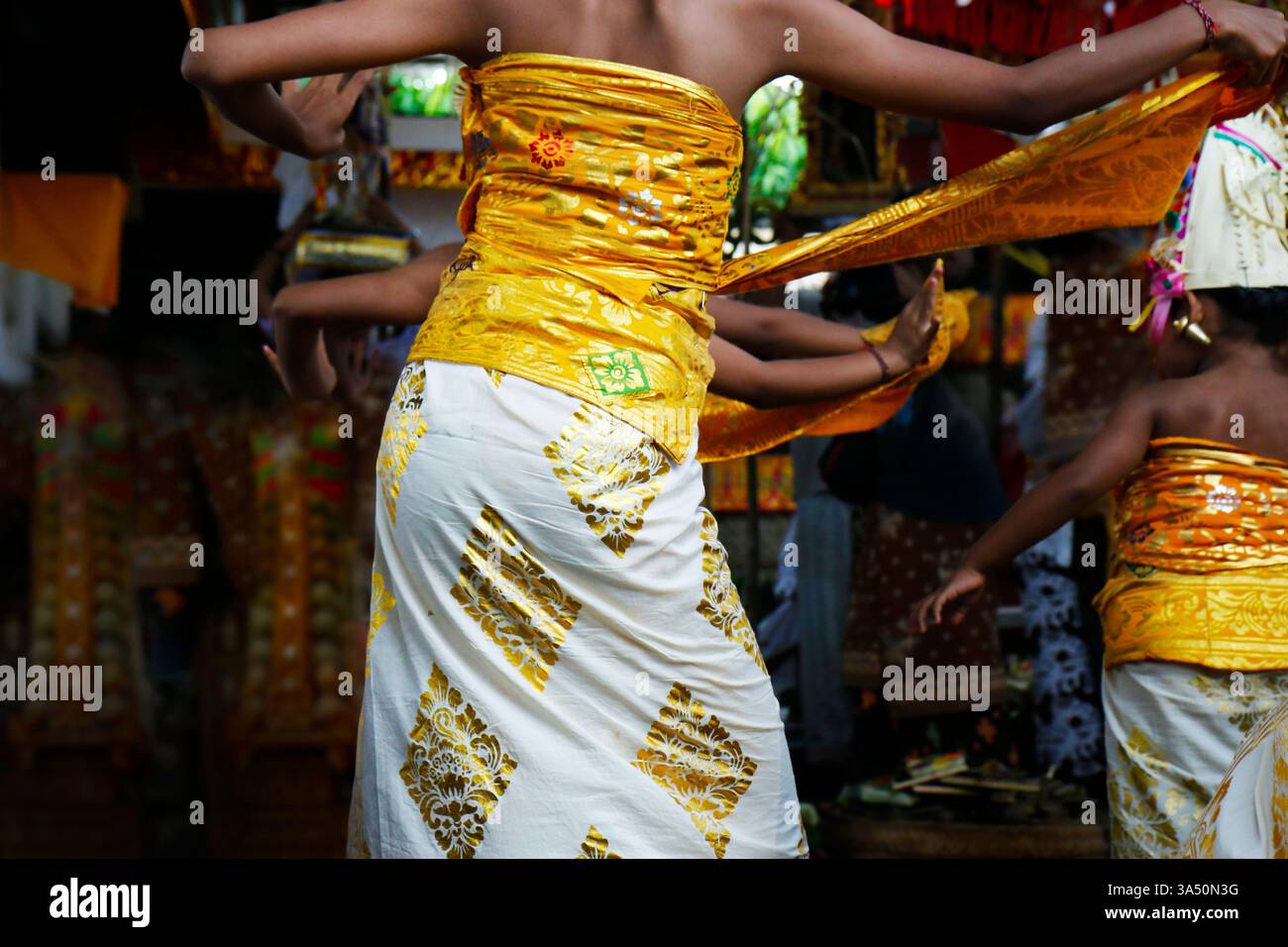 Femme balinaise dans un kebaya jaune et blanc danse le rejang lors d'une cérémonie de festival de Bali. Une image culturelle vivante pour les voyages en Indonésie, la culture balinaise, la danse traditionnelle et les festivals de temple. Banque D'Images