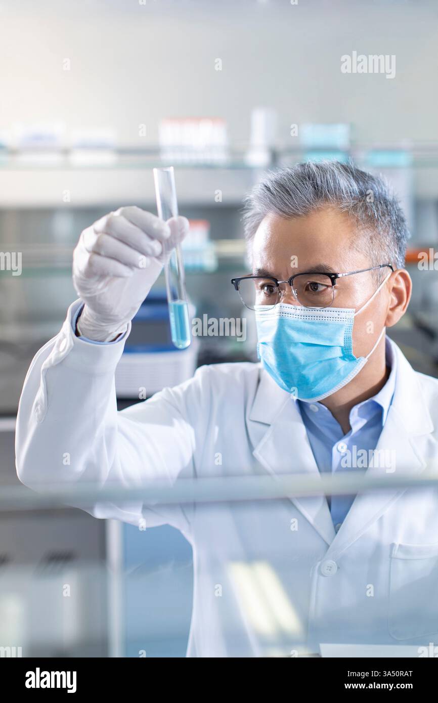 Un scientifique chinois examine un échantillon médical dans un laboratoire. Un thème de biotechnologie et de recherche adapté aux communications scientifiques et aux caractéristiques de santé. Idéal pour les histoires sur le travail en laboratoire et les découvertes scientifiques. Banque D'Images