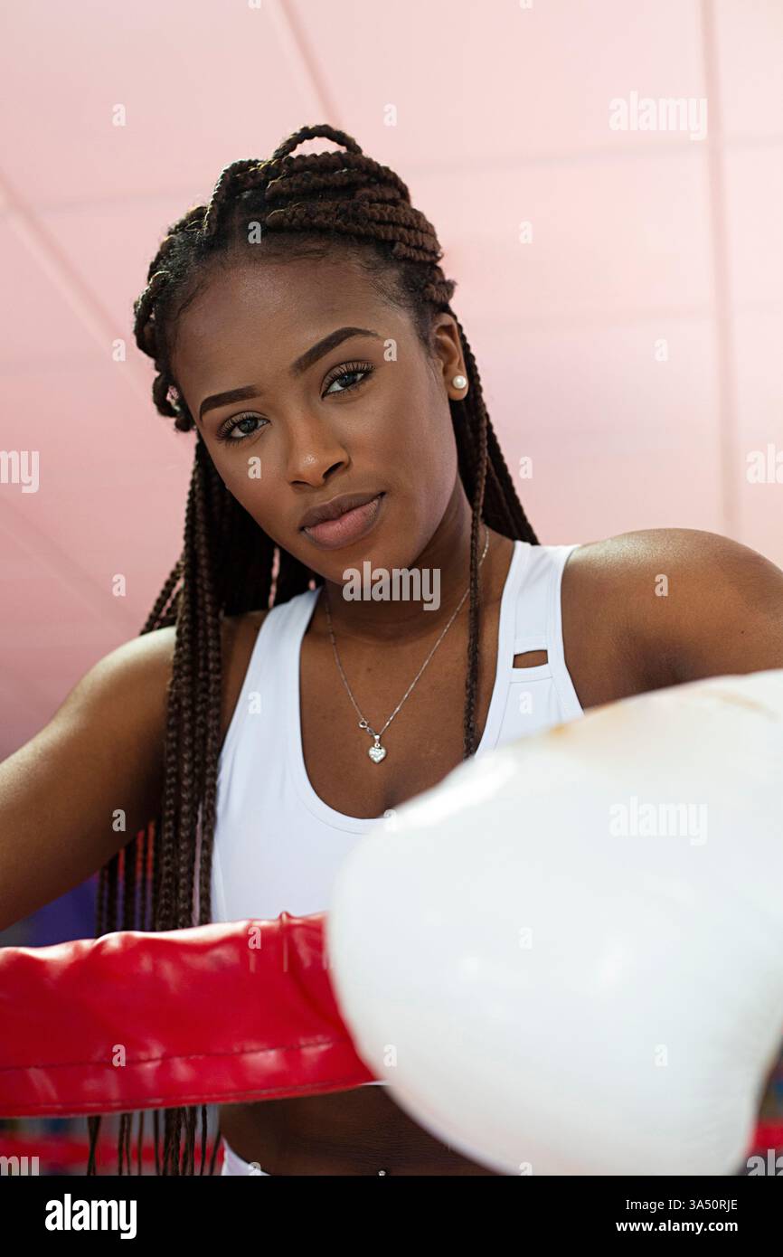 Femme afro-américaine dans un portrait de gymnastique de boxe portant des gants de boxe. Images dynamiques de fitness pour le sport, la boxe et les campagnes d'autonomisation des femmes. Idéal pour la gym, le bien-être et le marketing de style de vie sportif. Banque D'Images