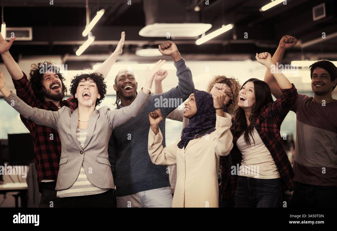 Portrait d'une équipe diversifiée de développeurs de logiciels debout ensemble et regardant la caméra alors qu'ils célèbrent le succès d'une startup moderne. Le groupe respire le travail d'équipe, la confiance et l'énergie entrepreneuriale dans un environnement de bureau contemporain. Parfait pour la technologie de marque, la collaboration et les histoires de start-up. Banque D'Images