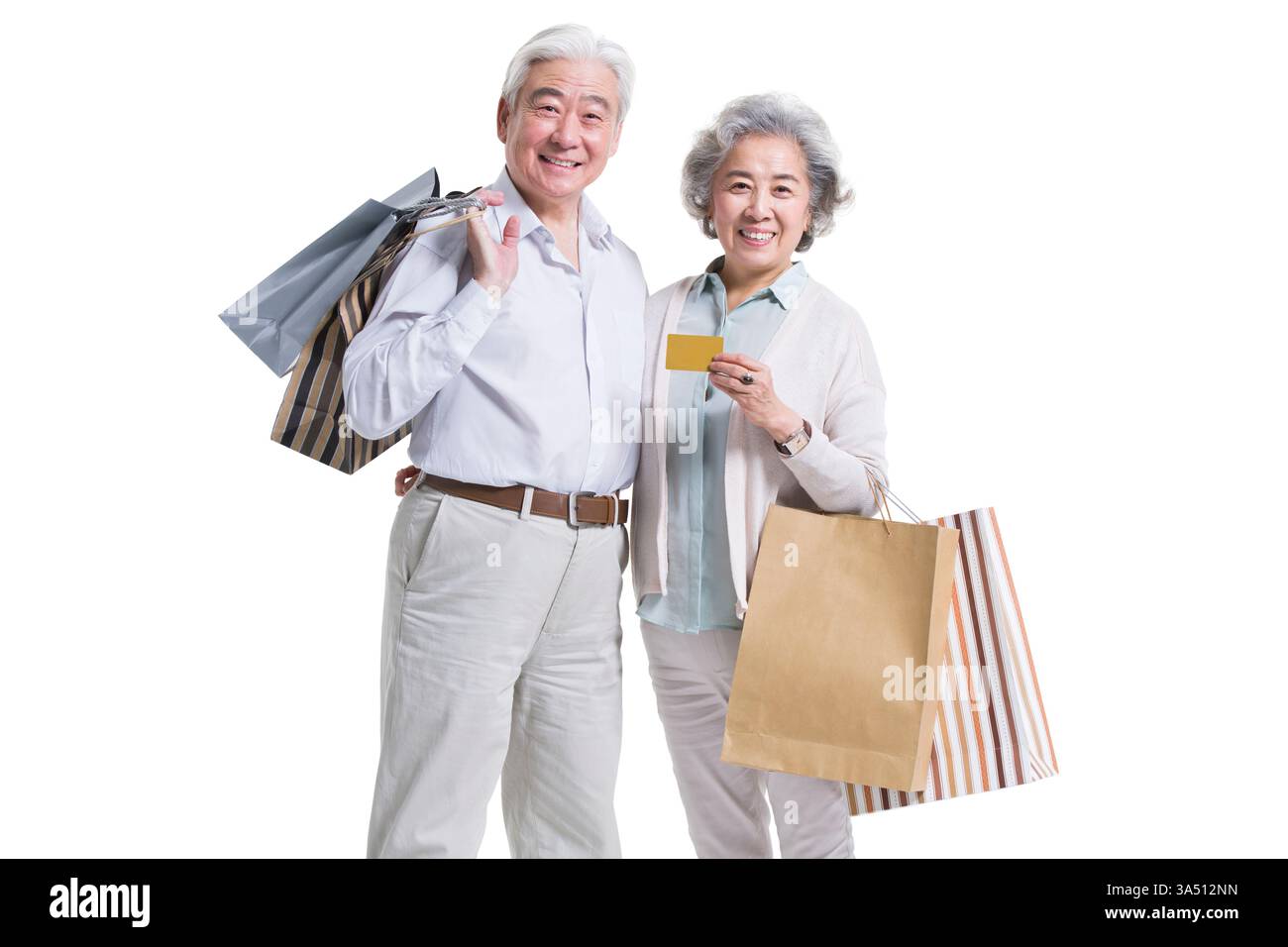 Couple chinois séniors magasinant ensemble, souriant avec une carte de crédit. La convivialité et les loisirs sont véhiculés dans une scène shopping, adaptée au style de vie, au consumérisme et aux thèmes familiaux en Chine. Banque D'Images