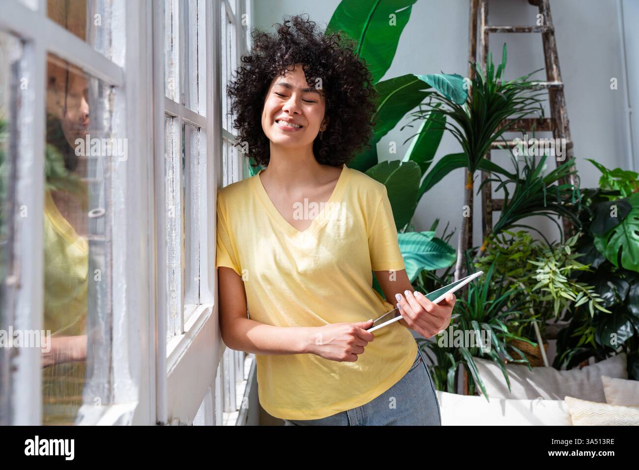 Belle femme Latina à la maison dans un cadre ambiant chaud. Cette image de style de vie de portrait montre la vie domestique et l'énergie positive. Parfait pour la vie à la maison, le travail à distance et le contenu de marque personnelle. Banque D'Images