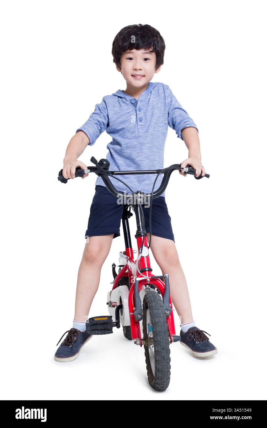 Souriant garçon chinois vélo d'équitation sur fond blanc dans le studio Banque D'Images