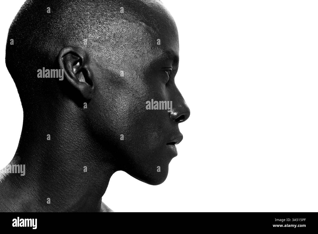 Gros plan portrait de côté d'un homme afro-américain confiant avec un regard pensif. Tête forte et moderne adaptée au style de vie, aux affaires et à la marque personnelle. Idéal pour les caractéristiques sur l'individualité, la contemplation et le style contemporain. Banque D'Images