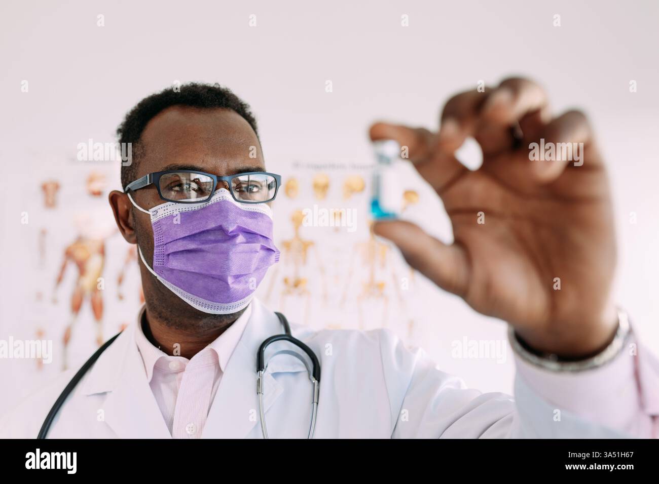 Médecin afro-américain portant un masque médical montrant une dose vaccinale dans sa main. Cette image de santé met l'accent sur la vaccination et les soins professionnels. Banque D'Images