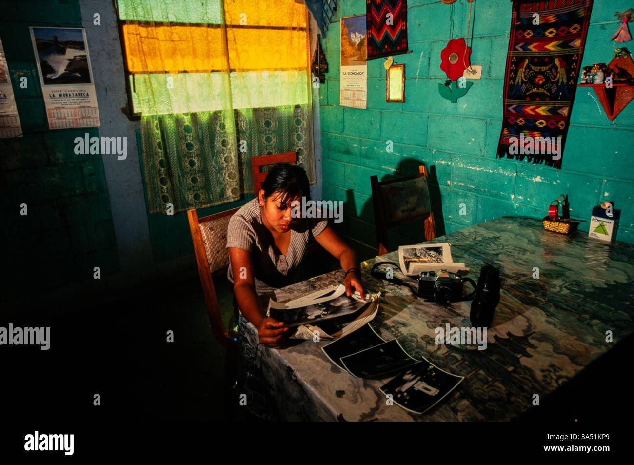 Une étudiante de la 'mari sol photo School' à la maison, regardant à travers son travail, Guatemala City, Guatemala. Banque D'Images