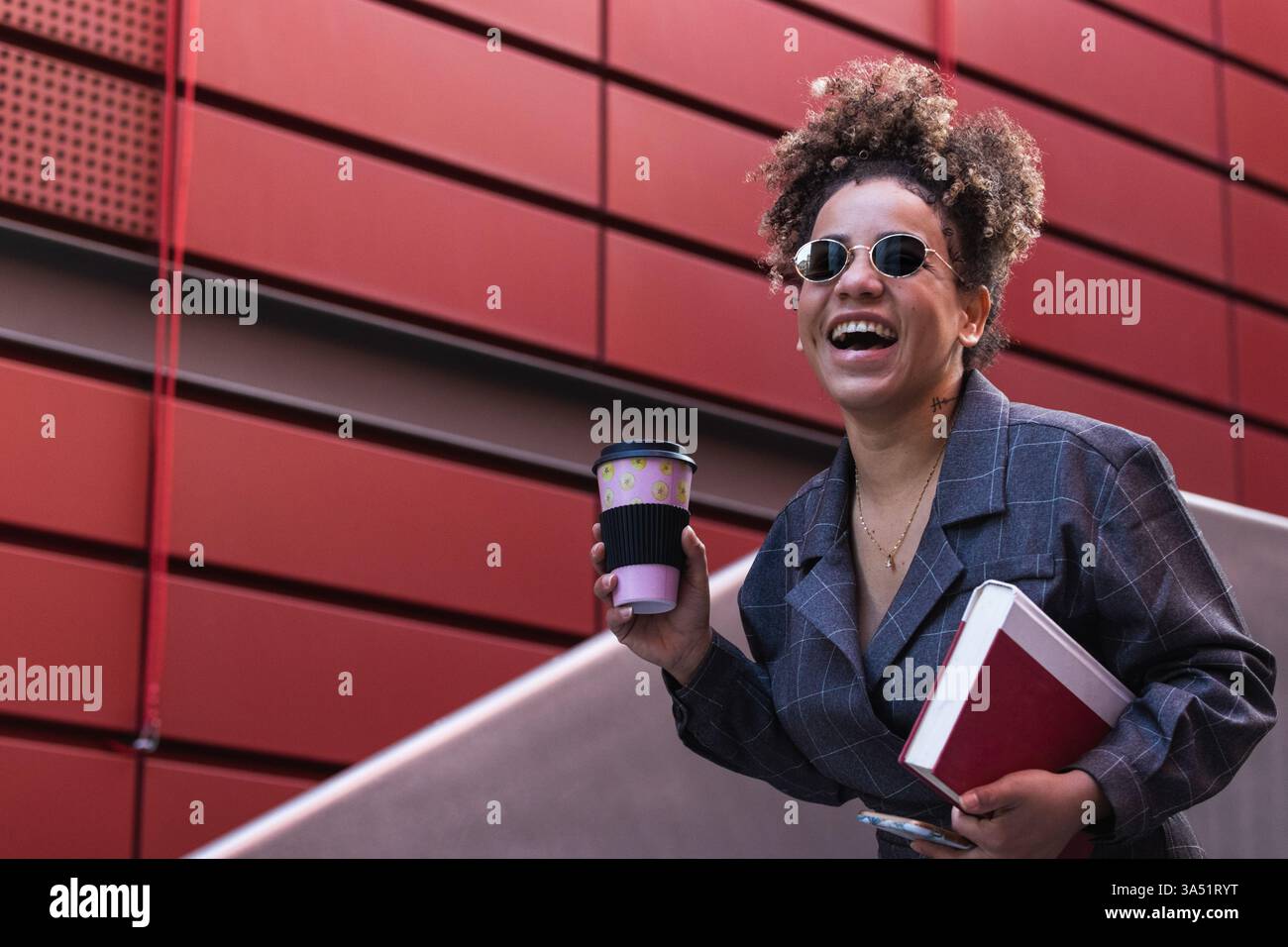 Portrait d'une étudiante d'université d'une femme hispanique marchant sur le campus avec des livres et un sac à dos. Idéal pour l'éducation, la vie étudiante, le marketing universitaire et les campagnes Gen Z. Banque D'Images