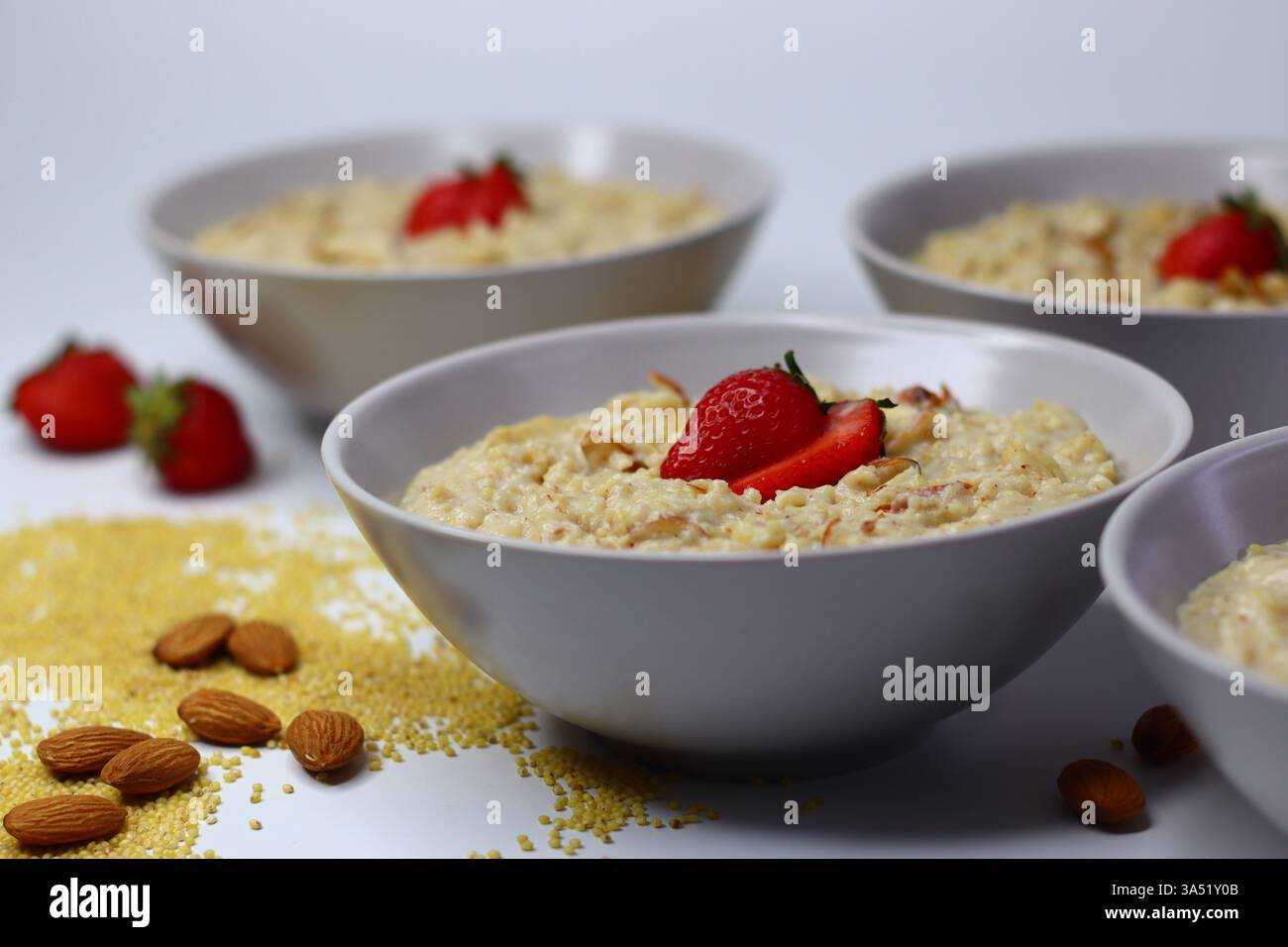 Bouillie de millet proso saine garnie de fraises fraîches tranchées dans un bol. Option de petit déjeuner nutritif riche en fibres et en antioxydants. Parfait pour Banque D'Images