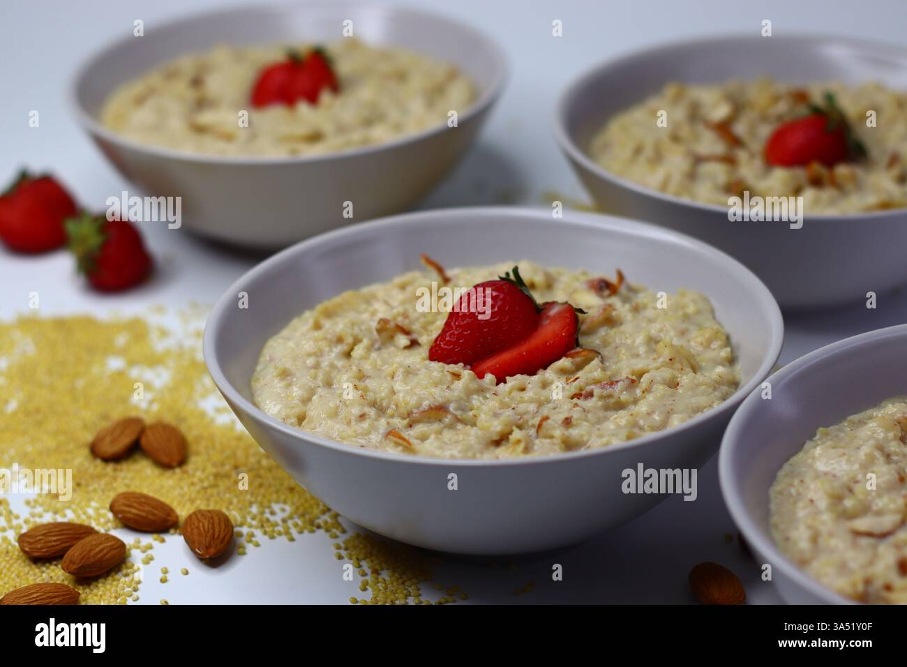 Bouillie de millet proso saine garnie de fraises fraîches tranchées dans un bol. Option de petit déjeuner nutritif riche en fibres et en antioxydants. Parfait pour Banque D'Images