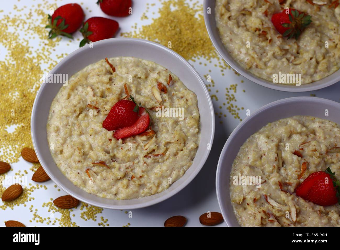 Bouillie de millet proso saine garnie de fraises fraîches tranchées dans un bol. Option de petit déjeuner nutritif riche en fibres et en antioxydants. Parfait pour Banque D'Images