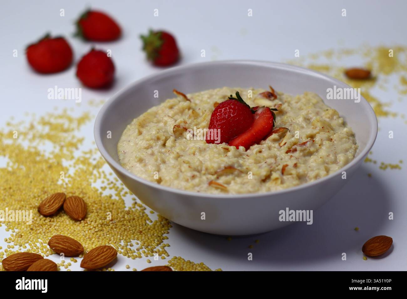 Bouillie de millet proso saine garnie de fraises fraîches tranchées dans un bol. Option de petit déjeuner nutritif riche en fibres et en antioxydants. Parfait pour Banque D'Images
