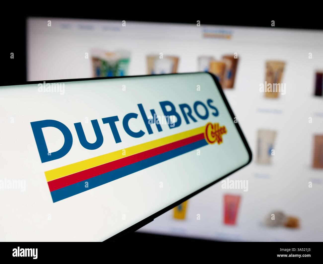 Téléphone portable avec le logo de la chaîne de café américaine Dutch Bros Inc sur l'écran en face du site Web de l'entreprise. Banque D'Images