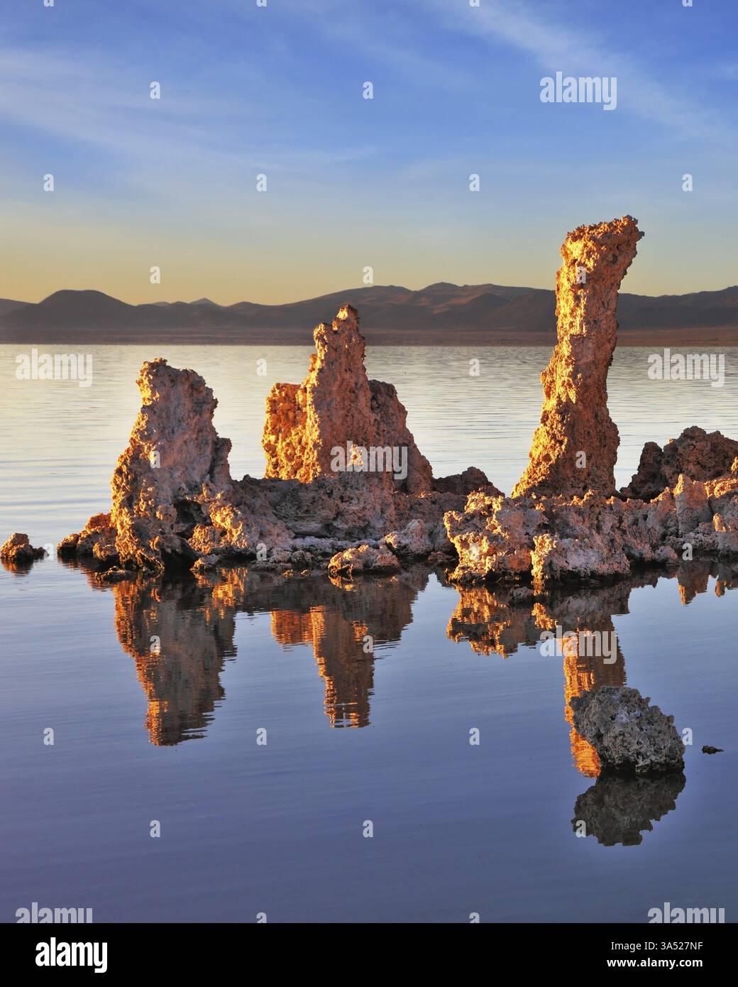 Le coucher de soleil pittoresque au lac Mono. Aberrations - formation bizarre de tuf calcaire reflétée dans l'eau lisse Banque D'Images