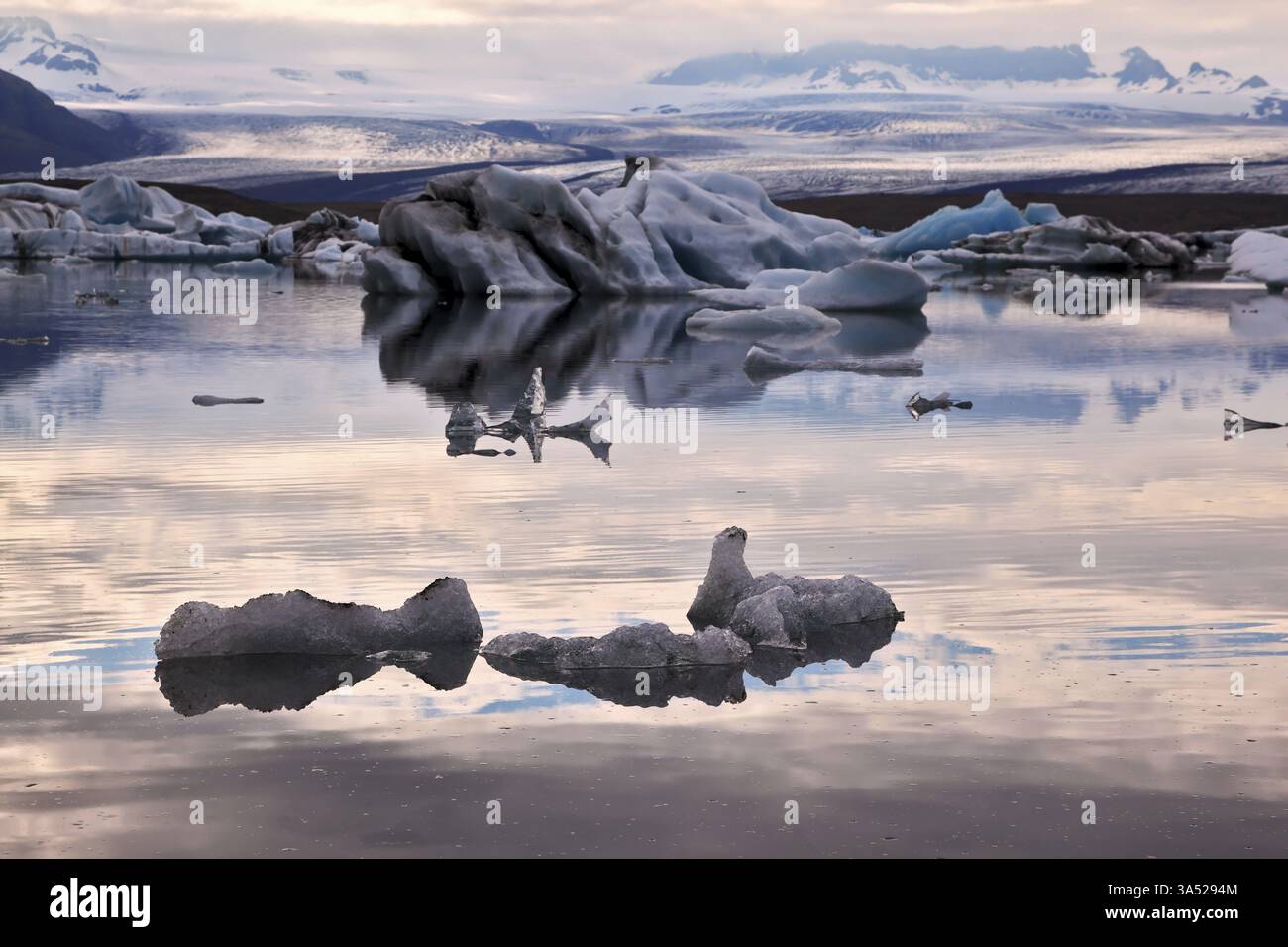 Icebergs translucides dans le lagon de glace Jokulsarlon. Sud-est de l'Islande. Coucher de soleil rose en juillet Banque D'Images