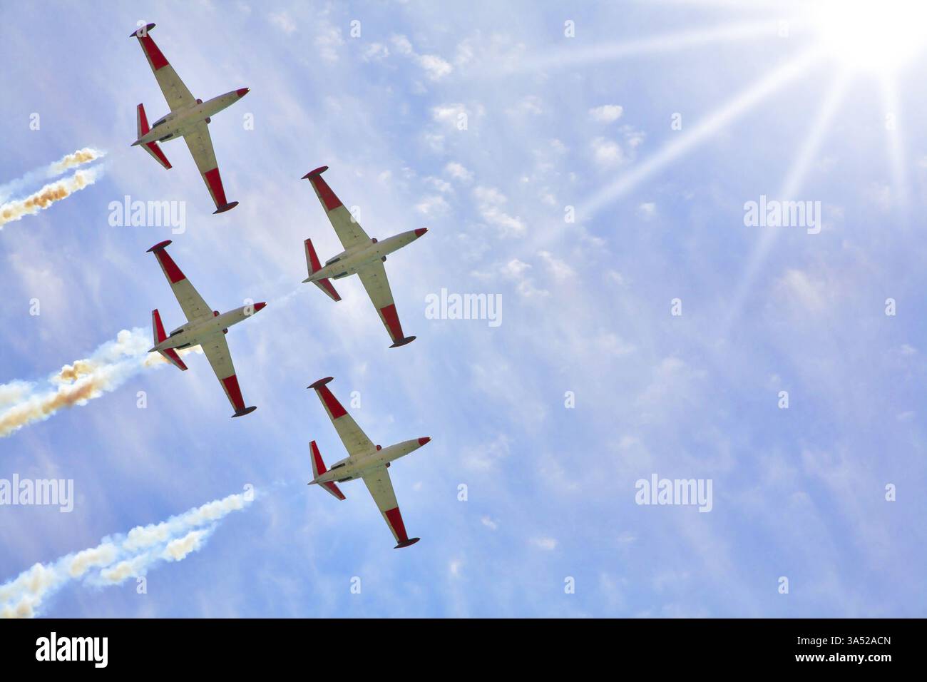 Vol synchrone dans les faisceaux du soleil de quatre avions mousseux sur la parade festive Banque D'Images Vol synchrone dans les faisceaux du soleil de quatre avions mousseux sur la parade festive Banque D'Images