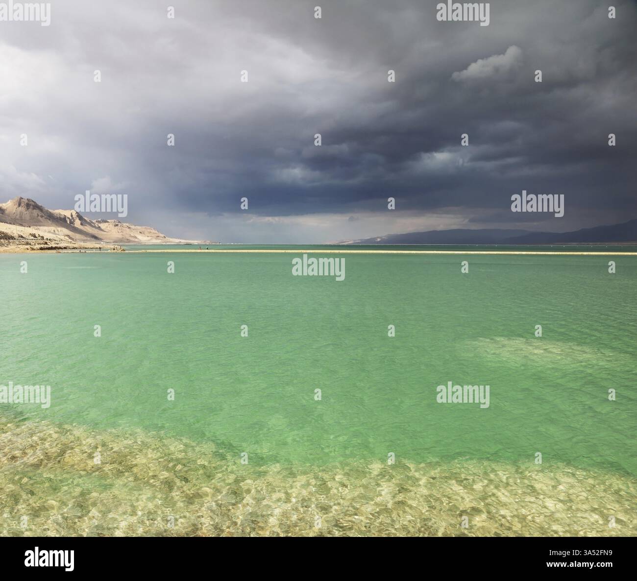 Coucher de soleil. Effets d'éclairage incroyables dans un orage à la mer morte. Eau multicolore dans les bas-fonds Banque D'Images