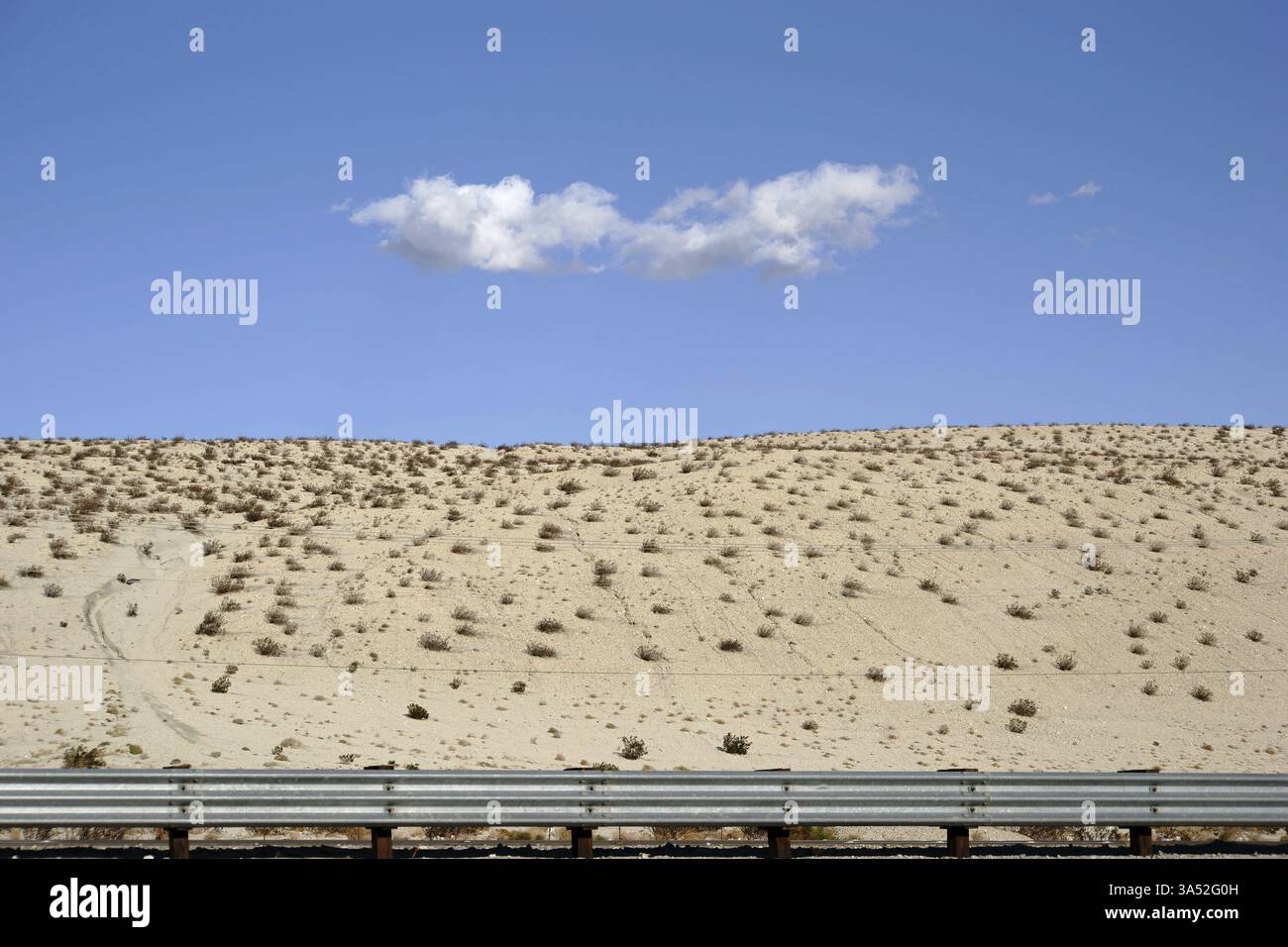 Un seul nuage au-dessus des collines sablonneuses du désert près de la vallée de Yucca Banque D'Images