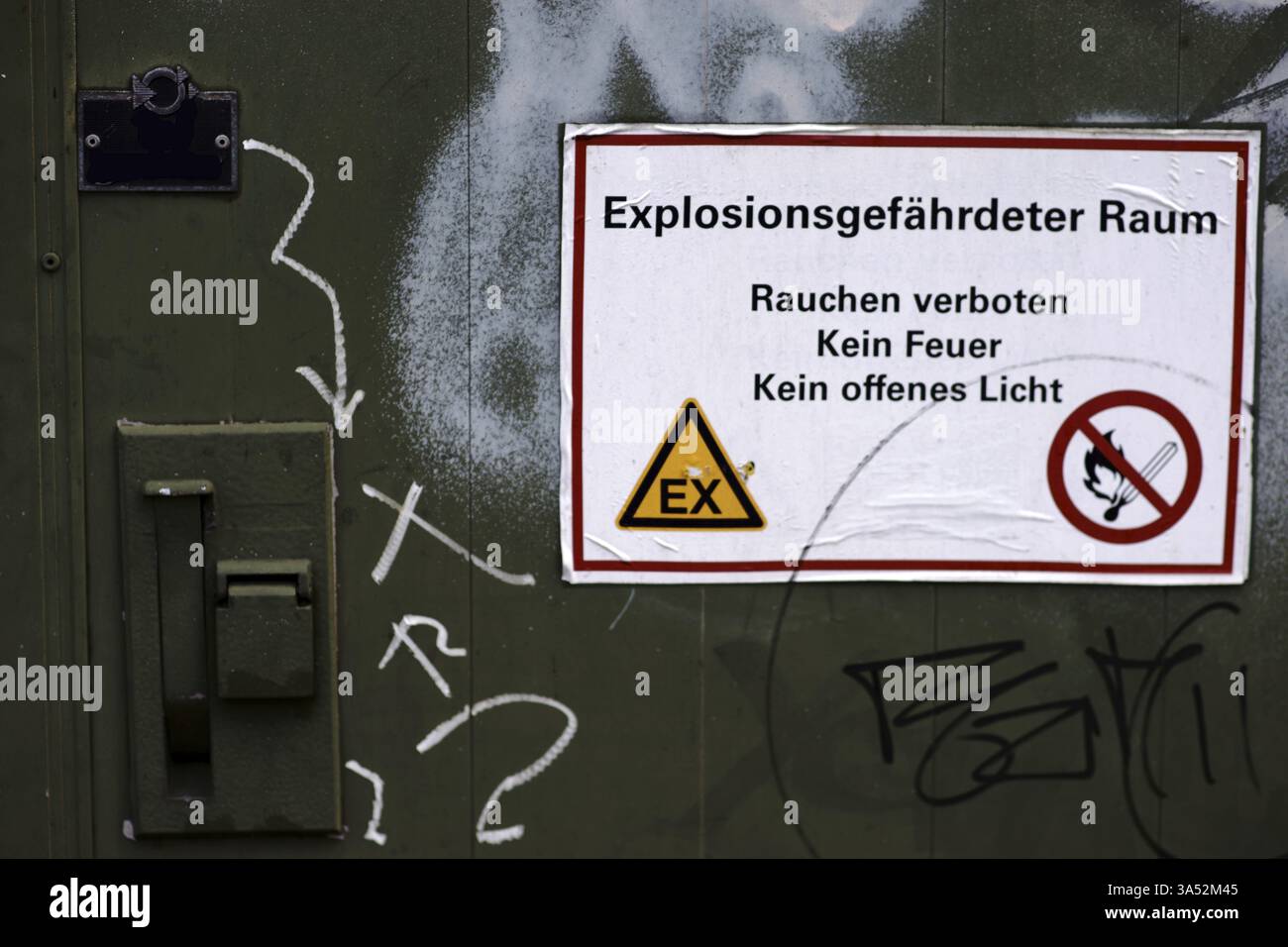 Un réservoir de produits chimiques avec une porte verrouillable et sécurisée et un panneau d'avertissement : attention, atmosphère potentiellement explosive Banque D'Images