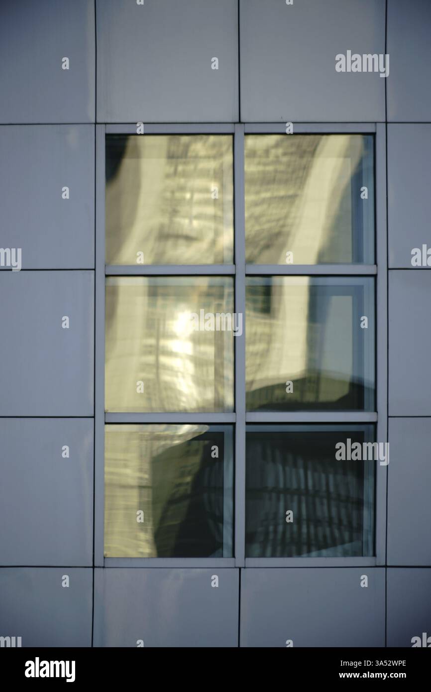 Reflets abstraits dans des fenêtres carrées sur une façade frappante faite de panneaux de tôle Banque D'Images