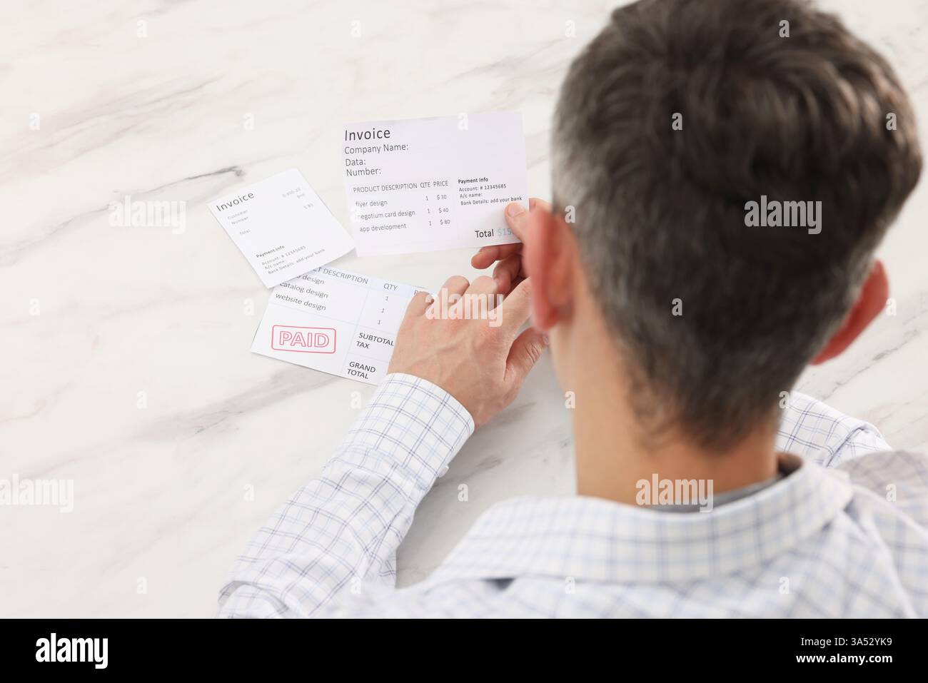Payer des factures. Homme avec différentes factures à la table en marbre blanc, vue au-dessus Banque D'Images