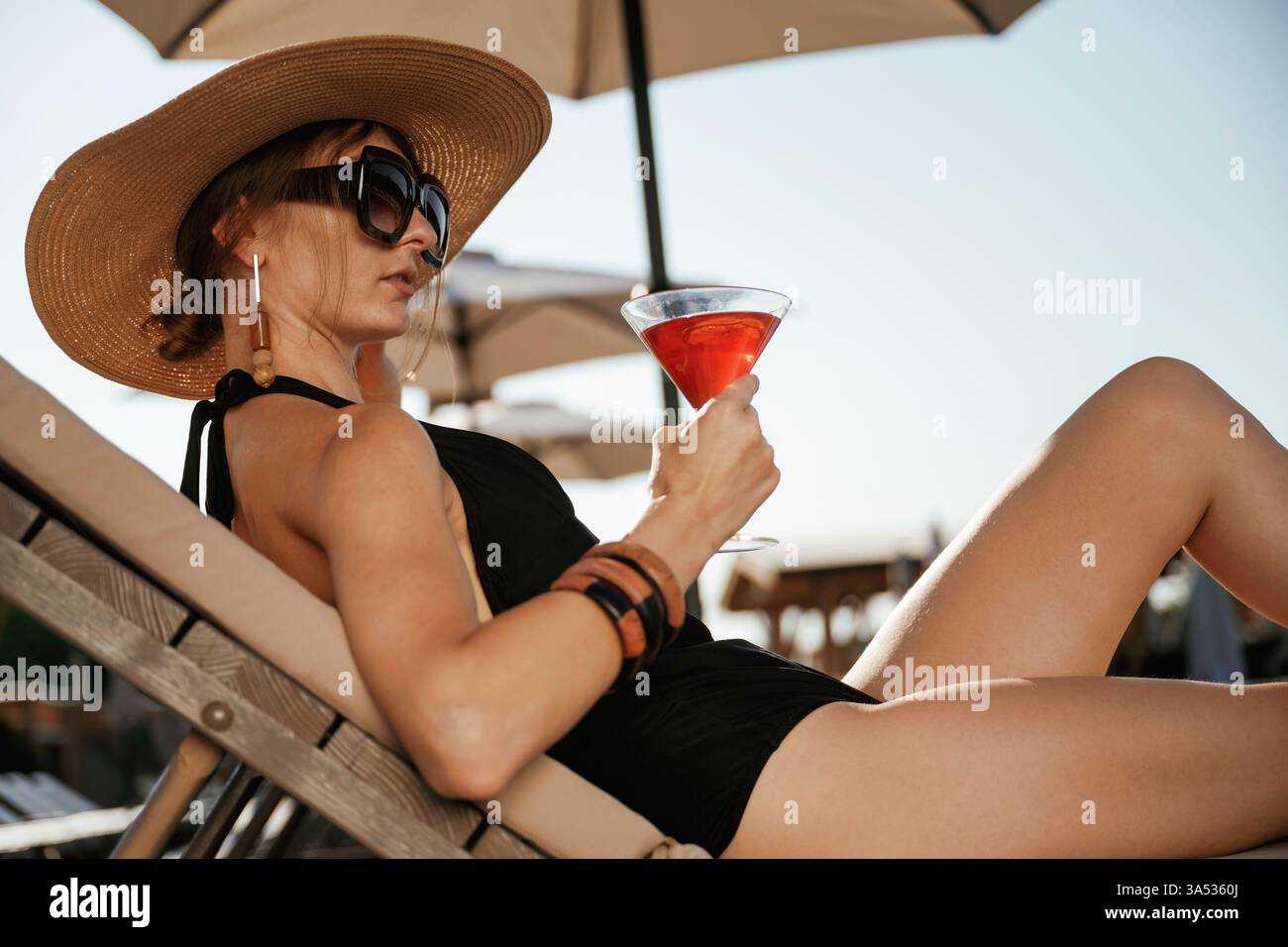 Boisson rafraîchissante à la main. Belle jeune femme est à la station, vacances. Banque D'Images