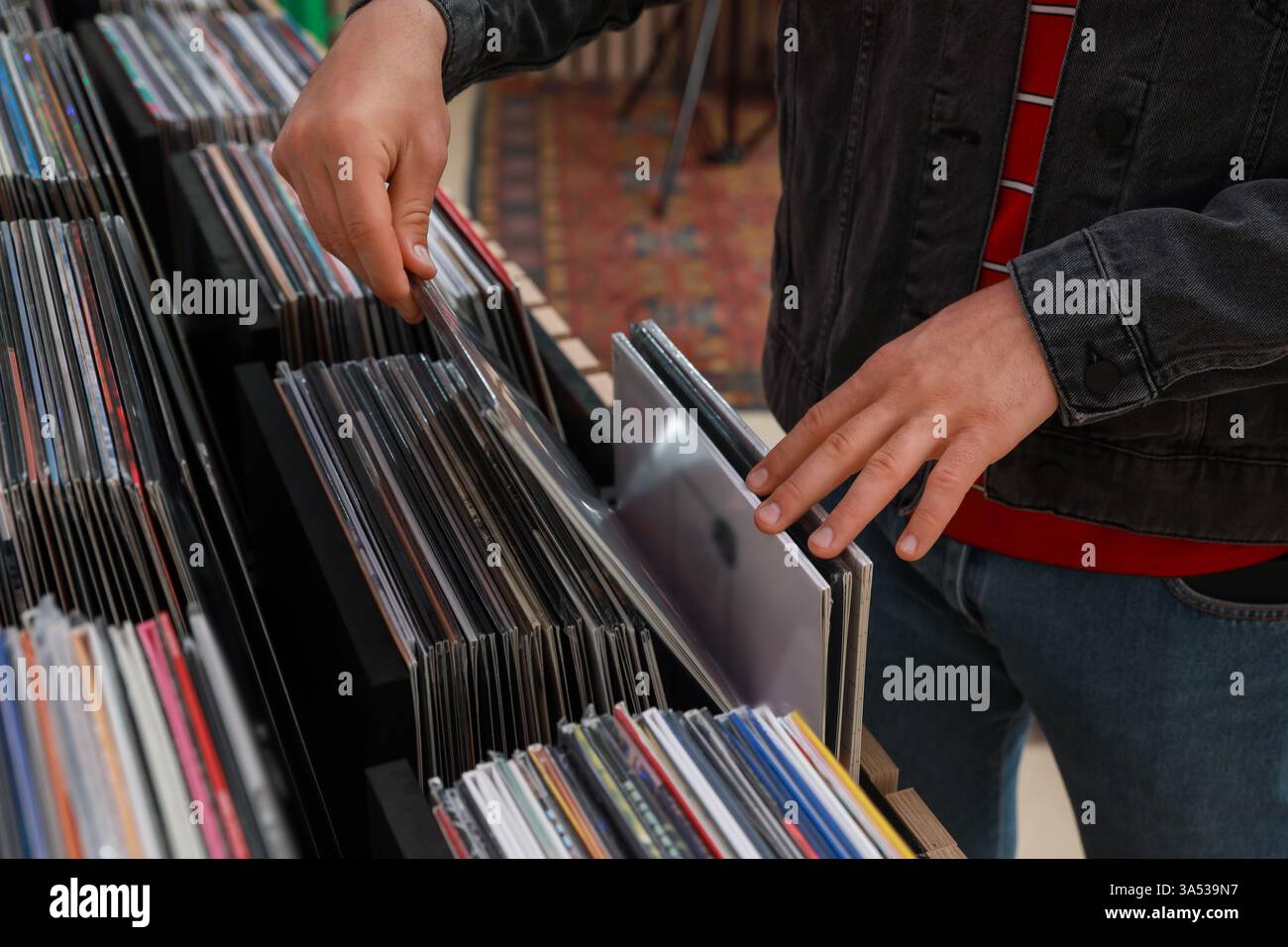 Homme qui choisit des disques vinyles en magasin, gros plan Banque D'Images