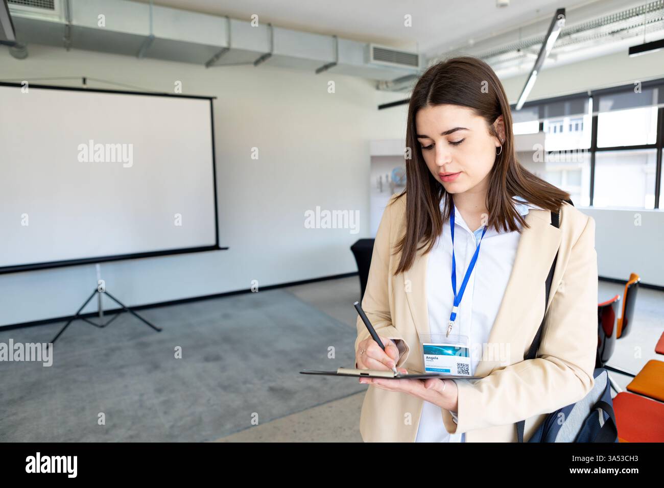 Femme d'affaires écrivant des notes sur tablette dans la salle de conférence, préparant la présentation, espace de copie Banque D'Images
