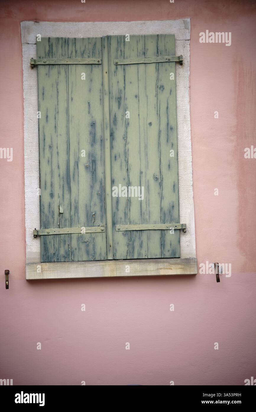 Un vieux volet fermé en bois et fané sur une fenêtre nostalgique Banque D'Images