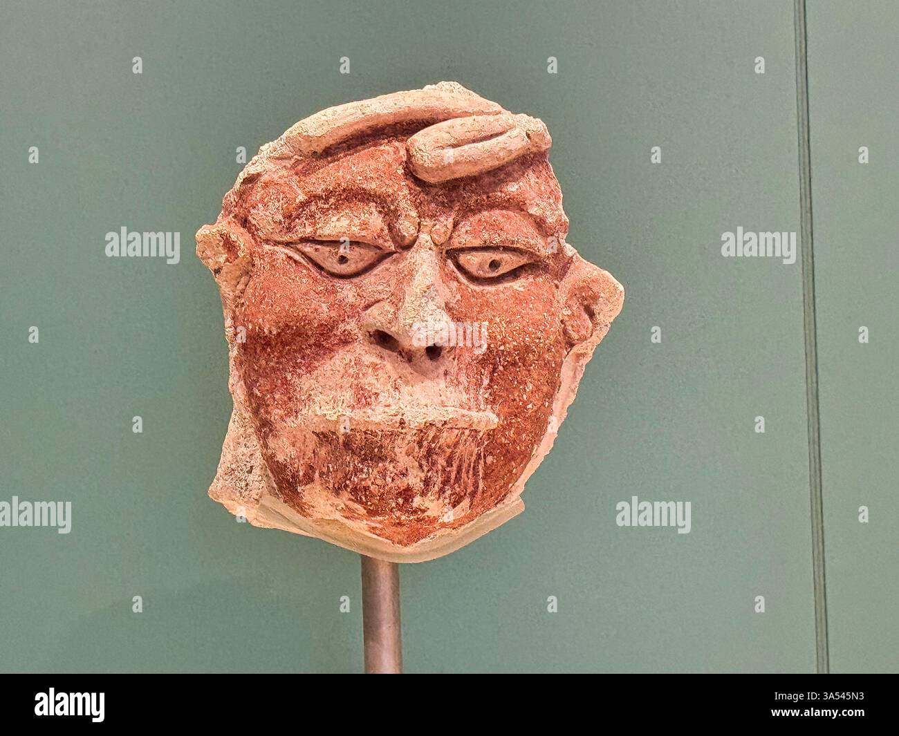 Masque polychrome peint en plâtre de stuc d'un captif avec des lèvres cousues du site maya Dzibanche, 600 à 850 EC au Museo de Maya, Cancun, Mexique Banque D'Images