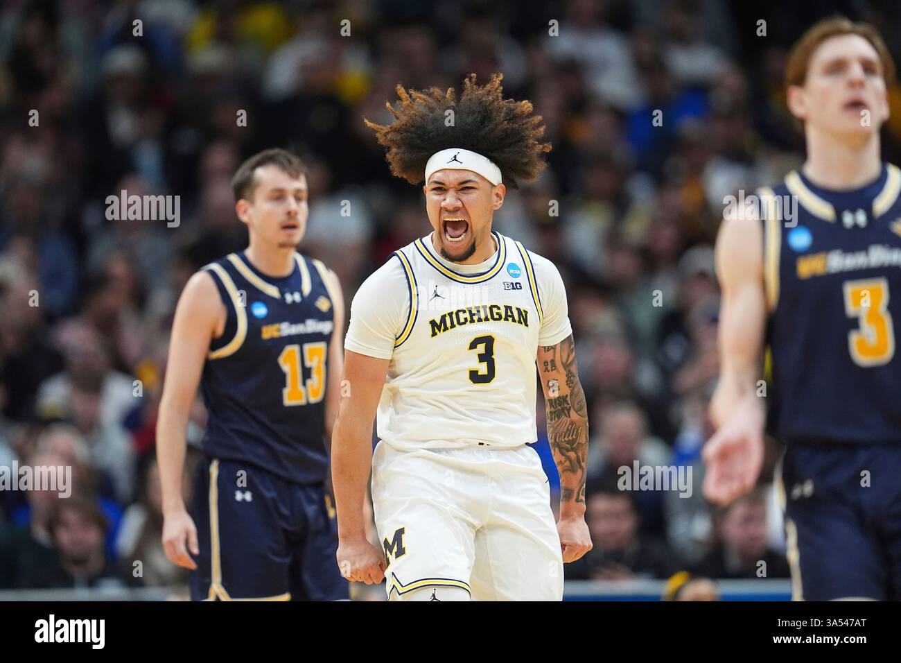 Michigan guard Tre Donaldson, center, reacts after scoring a basket as UC San Diego guards Tyler McGhie, back, and Hayden Gray drop back on offense during the first half in the first round of the NCAA college basketball tournament Thursday, March 20, 2025, in Denver. (AP Photo/David Zalubowski) Banque D'Images