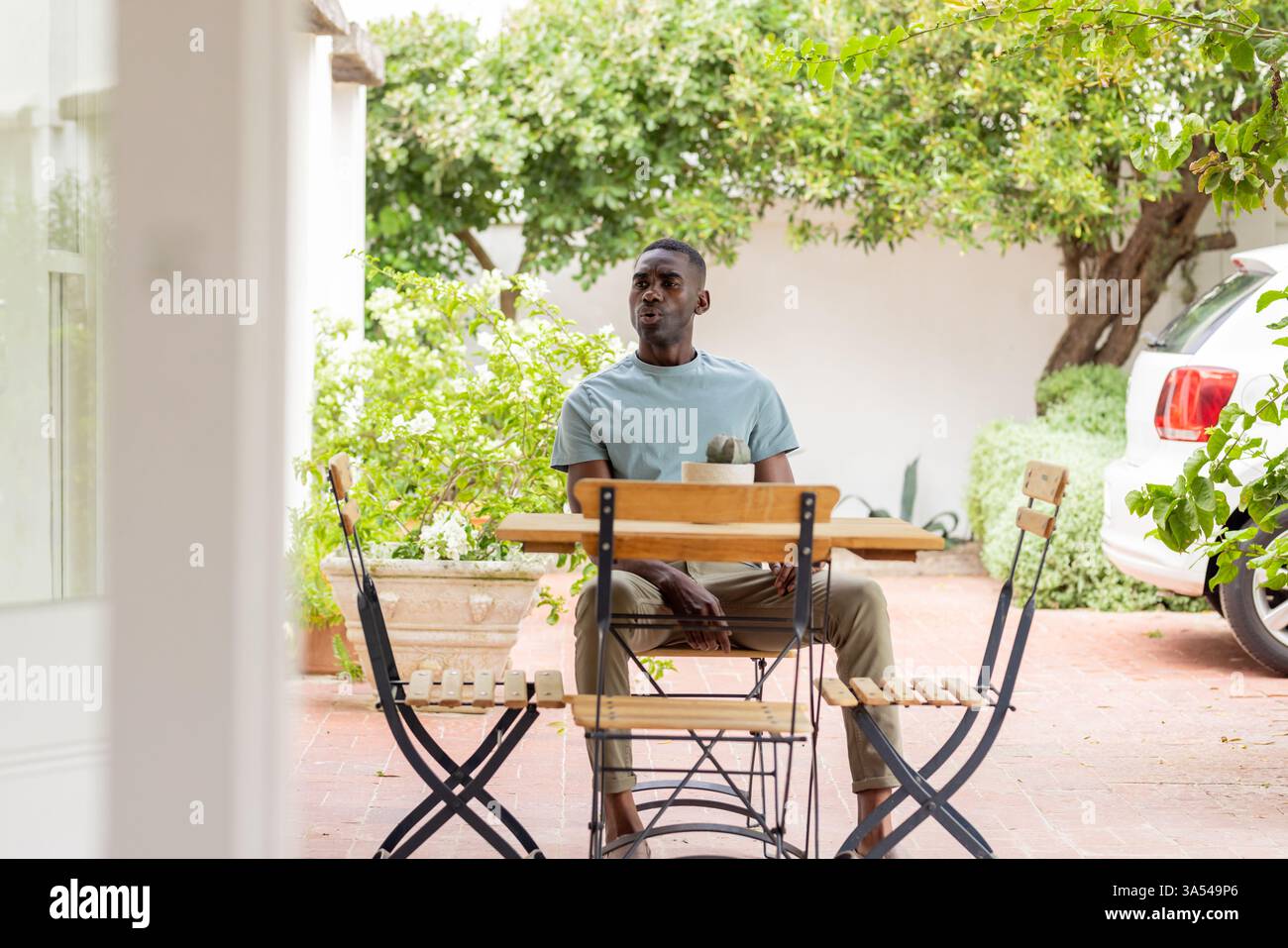 Détente au café en plein air, homme afro-américain savourant des moments de vacances paisibles Banque D'Images