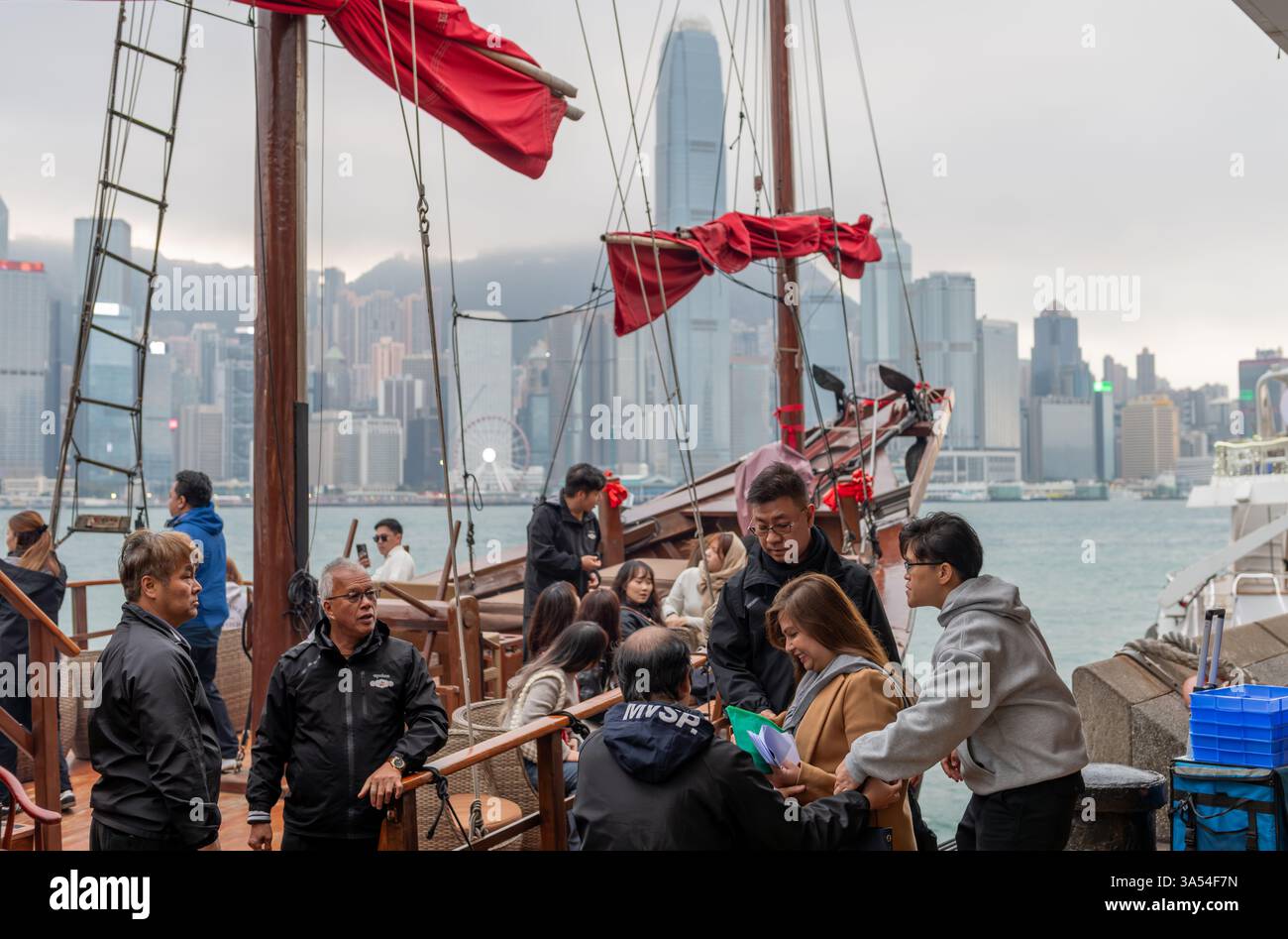 Hong Kong. Chine- 02.20.2025. Les touristes embarquent à bord de la jonque chinoise, Aqua Luna, pour une croisière emblématique de Hong Kong depuis le port de Victoria. Banque D'Images