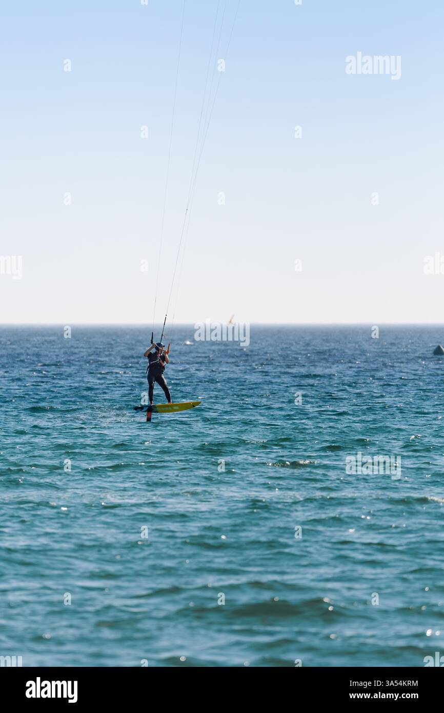 Plus vieux mais en forme de kitesurfer glissant à travers l'océan sur une planche d'hydroptère. Banque D'Images