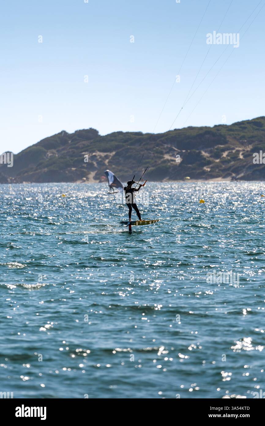 Un cerf-volant senior en forme chevauchant une planche d'hydroptère au-dessus de la mer, Tarifa, Espagne Banque D'Images