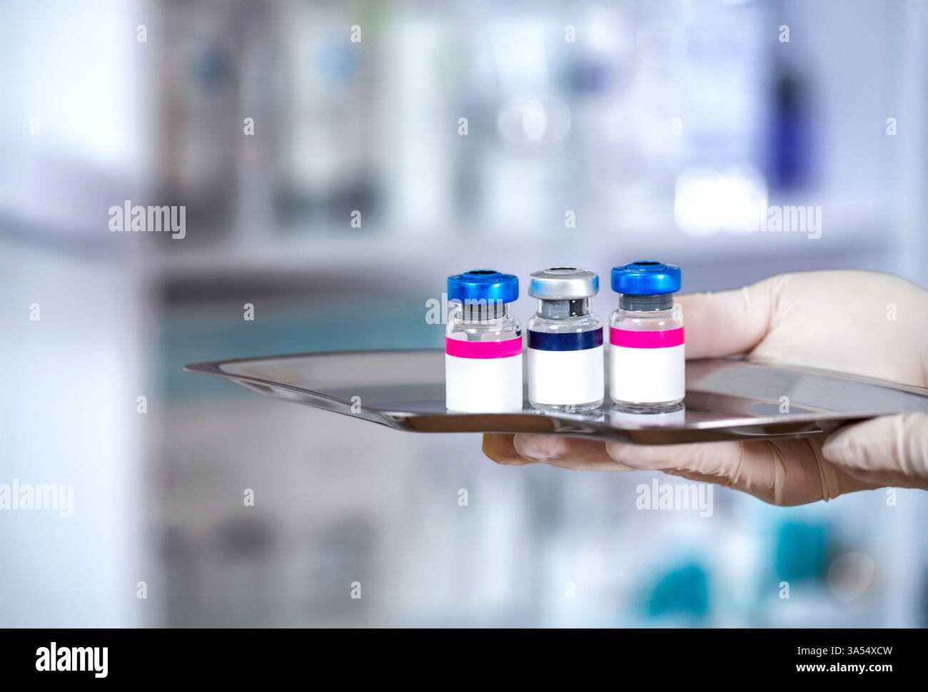 Flacons de vaccin médical avec étiquette blanche vierge dans la main d'un scientifique avec des gants en caoutchouc blanc. Gros plan de la main tenant des flacons de vaccin en verre pour Banque D'Images