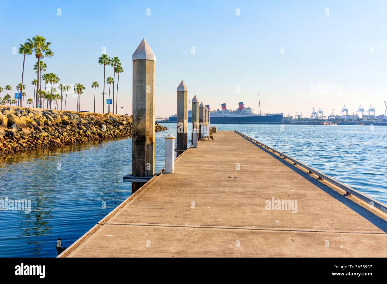 Long Beach, Californie - 11 janvier 2025 : navire emblématique Queen Mary amarré à long Beach, Californie, avec des palmiers bordant le pittoresque front de mer. Banque D'Images