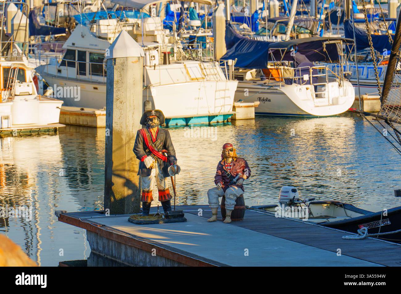 Long Beach, Californie - 11 janvier 2025 : statues complexes de pirates assis sur un quai avec voiliers amarrés et yachts à long Beach Marina pendant gol Banque D'Images