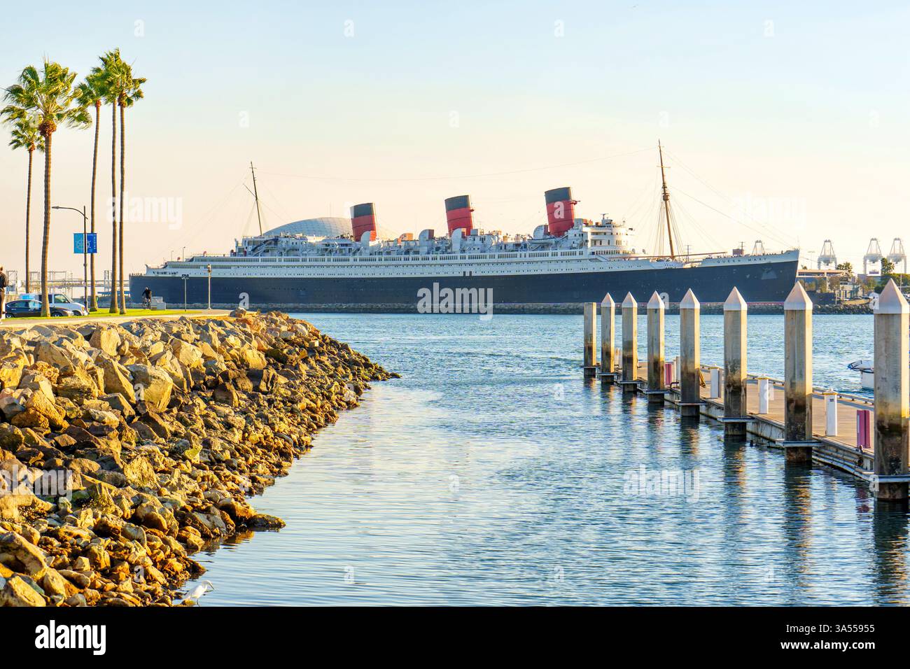 Long Beach, Californie - 11 janvier 2025 : L'emblématique paquebot Queen Mary est amarré à long Beach, Californie, entouré de palmiers, vue sur le port, Banque D'Images