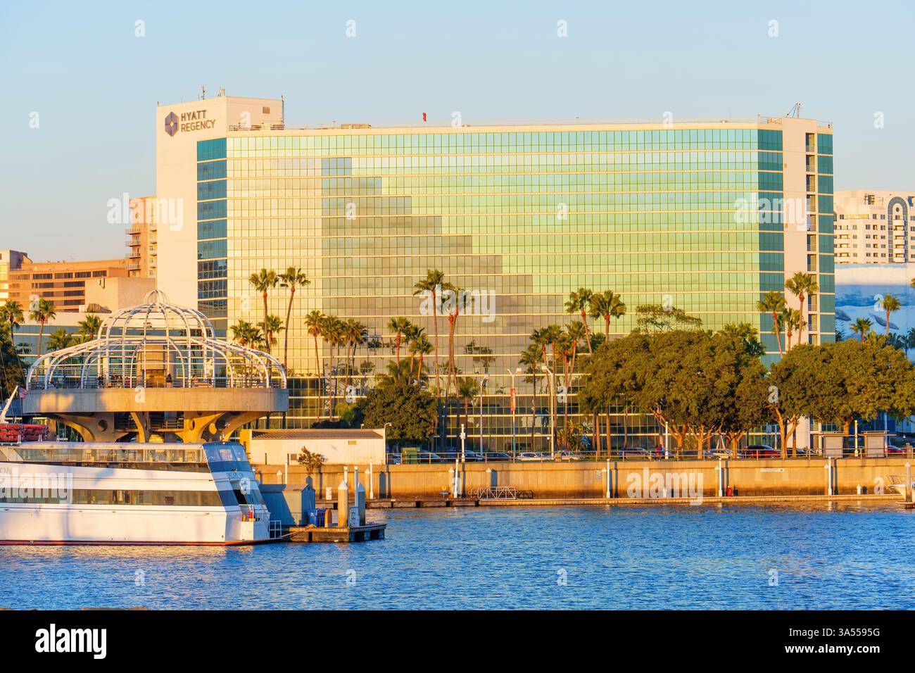 Long Beach, Californie - 11 janvier 2025 : façade en verre réfléchissante du bâtiment Hyatt Regency à long Beach, Californie, avec vue sur le port, palmiers, Banque D'Images