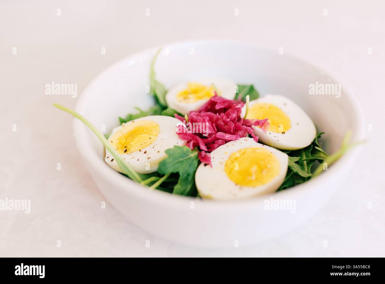 Saladier frais avec œufs durs, roquette et sac de cabré mariné Banque D'Images