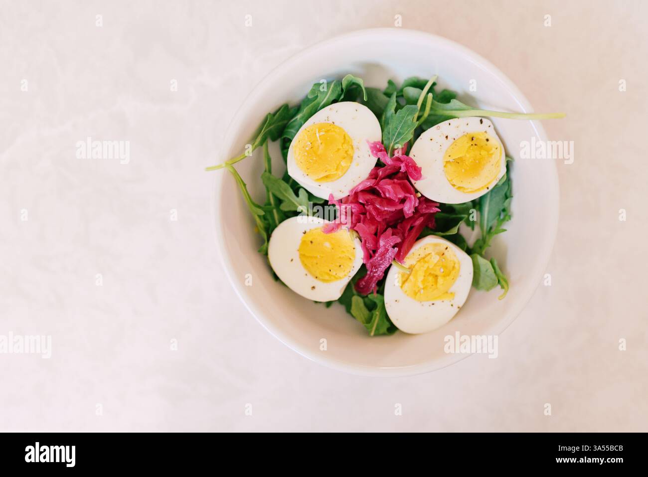 Saladier frais avec œufs durs, roquette et sac de cabré mariné Banque D'Images