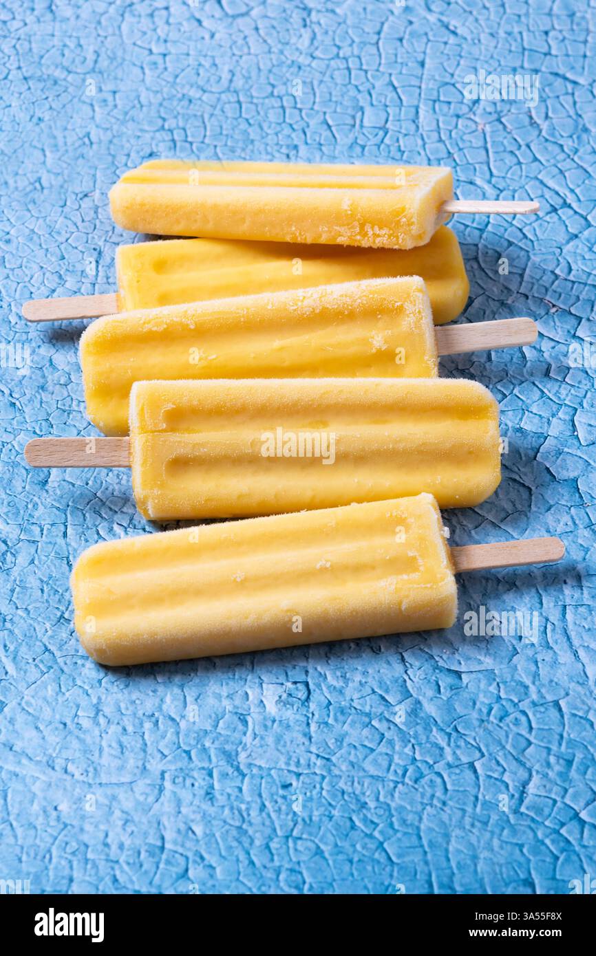 Popsicles jaunes sur fond bleu Banque D'Images