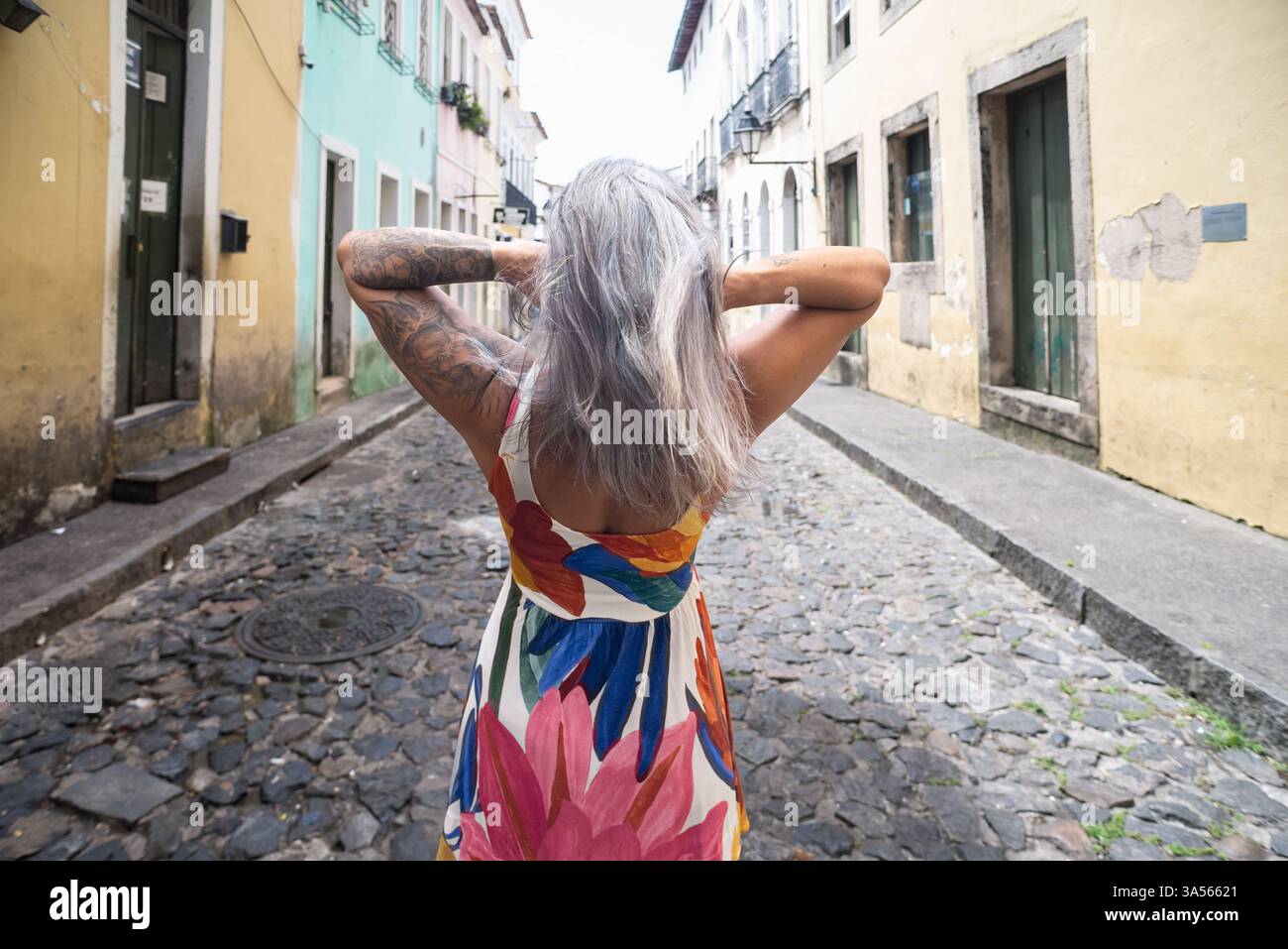 Femme portant une robe colorée avec son dos à la caméra contre de vieilles maisons en arrière-plan. Personne voyageant. Amérique du Sud. Banque D'Images